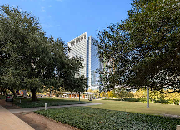 A park with a tall building in the background.