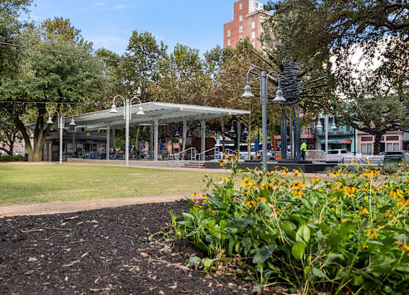 A park with a pavilion, trees, and flowers.