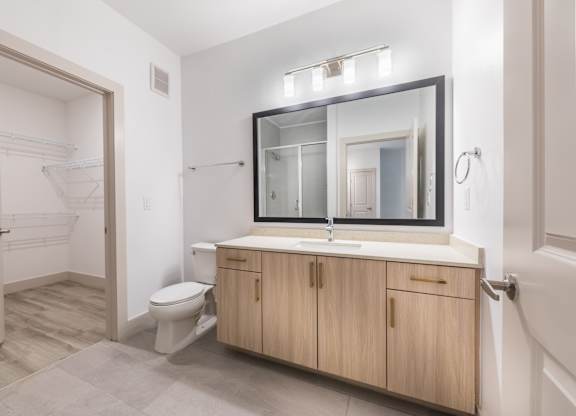 Bathroom with light wood cabinets at 1900 Parmer Apartments in Austin TX