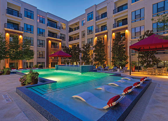A swimming pool in front of apartment buildings.