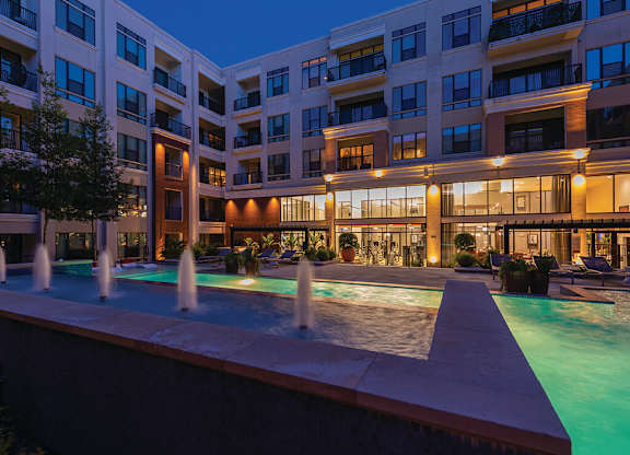 A large building with a pool in front of it.