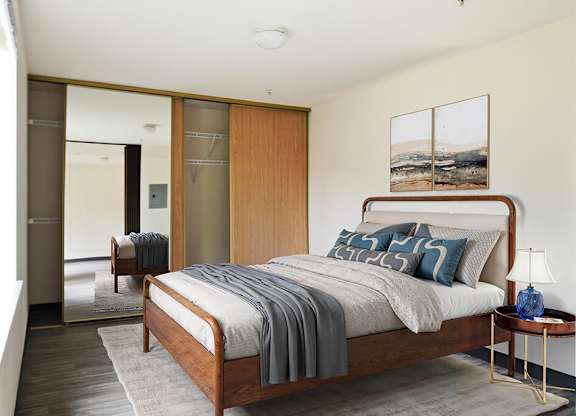 A bedroom with a bed, a nightstand, and a chair.