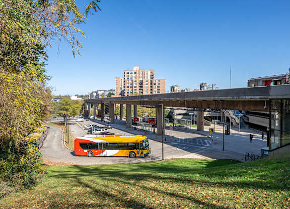 A yellow bus is parked on the side of a road at Belhaven Apartments in Alexandria VA