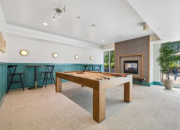 A room with a pool table and a fireplace.