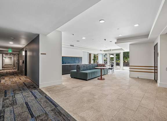 A spacious room with a blue sofa and a carpet with a geometric pattern.