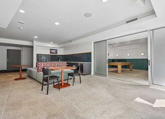 A modern dining room with a glass table and chairs.