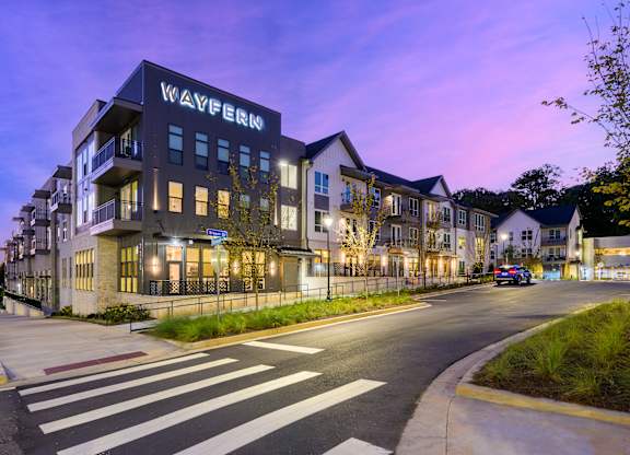 Exterior of building with lit up sign at Wayfern Apartments in Sandy Springs GA