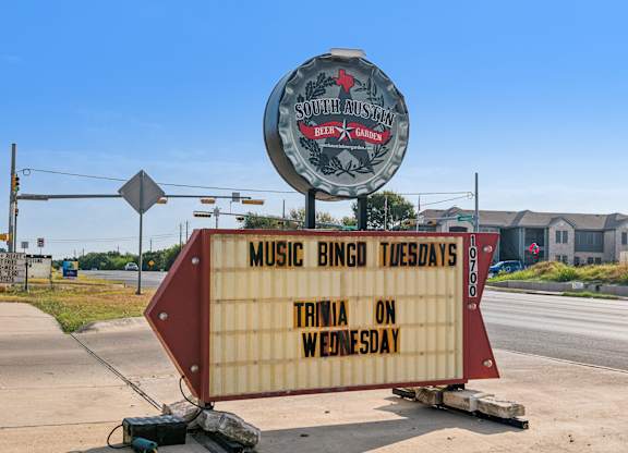 A sign for South Austin Beer Garden is displayed on a roadside.