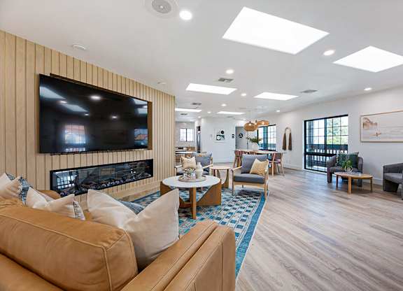 A living room with a large television and comfortable seating.