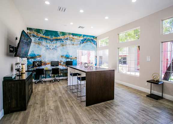 a home office with a large painting on the wall and a desk