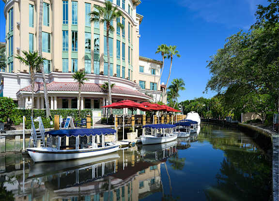 A boat is docked at a dock with a building in the background.