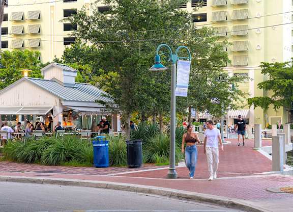 A street scene with people walking and a building in the background.