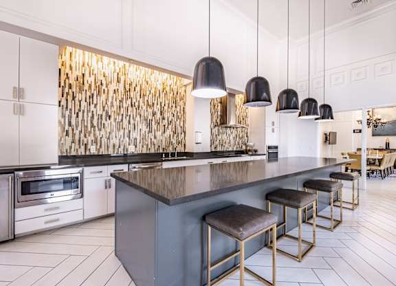 A modern kitchen with a dark countertop and stools.