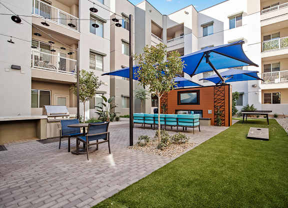 Courtyard with tables and TV at District at Scottsdale Apartments in Scottsdale AZ