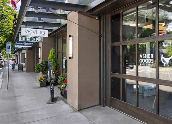 The image shows the front of a building with a glass door and a sign that reads