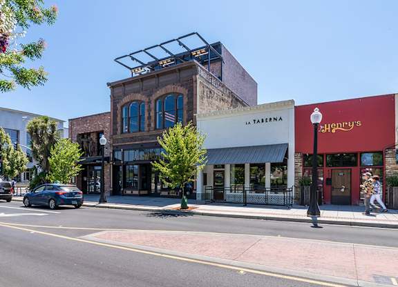 A street view with a car driving and a pedestrian walking