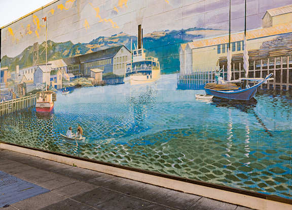 A mural of a harbor scene with boats and buildings