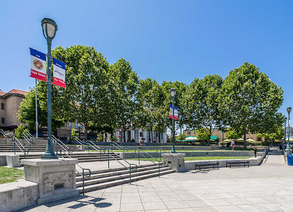 A park with benches and trees under a clear blue sky