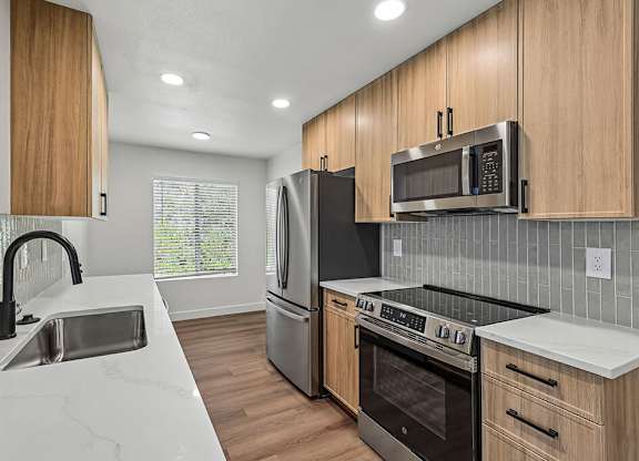 A modern kitchen with wooden cabinets and stainless steel appliances.