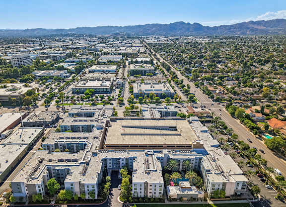 A large, modern complex of buildings is surrounded by a green landscape.
