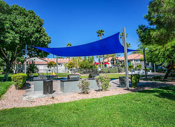 a picnic area with a blue canopy in a park