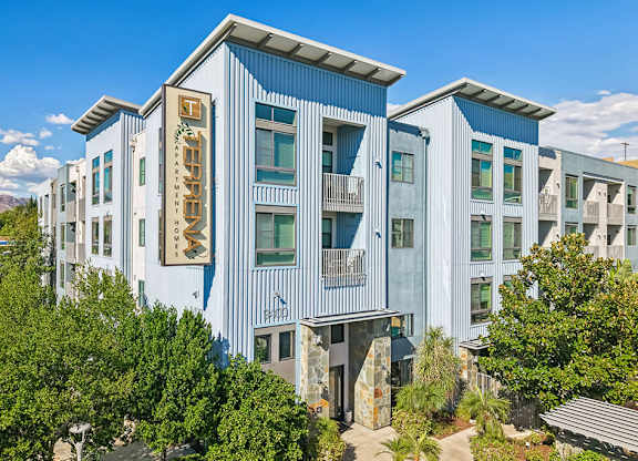 A modern building with a blue and white exterior and a stone entrance.