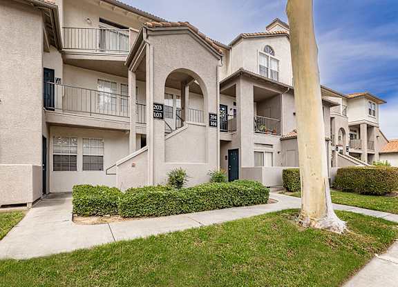 Lawn and exterior of apartments at Marquessa Villas Apartments and Townhomes in Corona CA