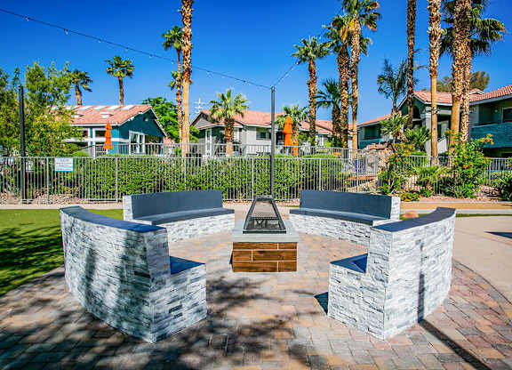 an outdoor patio with seating and a fire pit