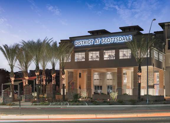 Exterior sign lit up at night at District at Scottsdale Apartments in Scottsdale AZ