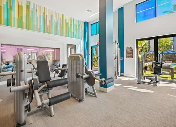 A gym with a row of exercise machines.