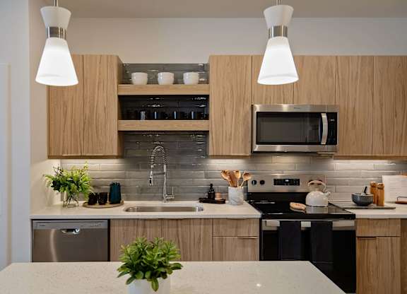 A kitchen with wooden cabinets and a black stove top oven.