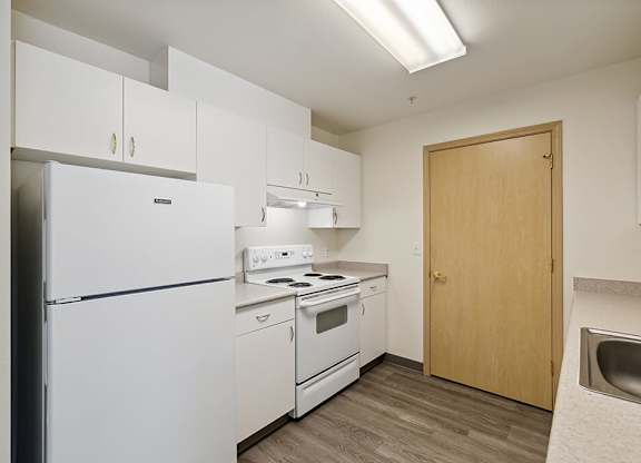 Kitchen with white appliances at Ballinger Court Senior Apartments in Edmonds WA