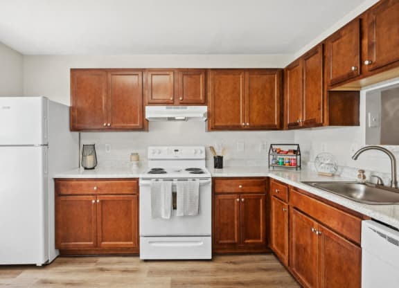 a kitchen with wooden cabinets and white appliances