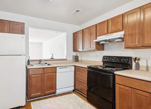 A kitchen with a black stove top oven and white appliances.