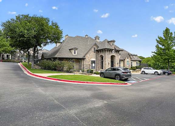A large house with a grey car parked in front.