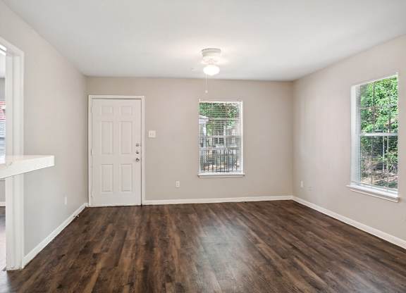 Living room with wood flooring at Park Village Apartments in Conroe TX