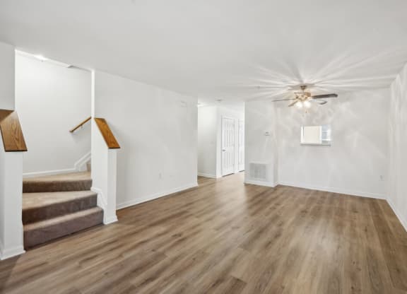 a living room with hardwood floors and a ceiling fan