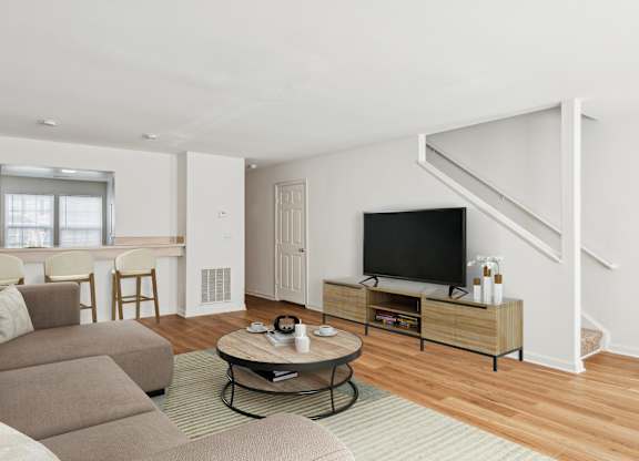 A living room with a couch, a coffee table, and a television.