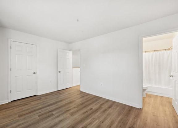 an empty living room with white walls and wood floors