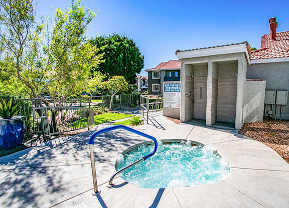 a hot tub in a backyard next to a house with a pool