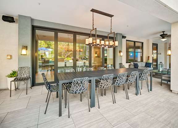 A modern dining room with a large table and chairs.