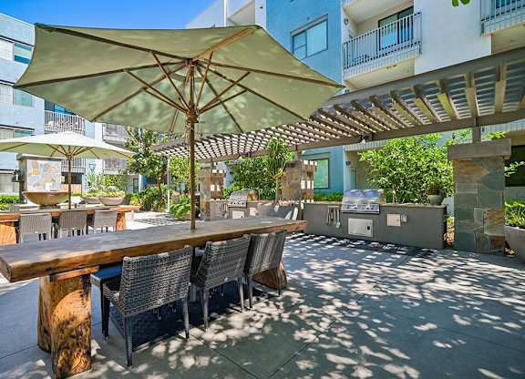 A patio with a table and chairs under a large umbrella.