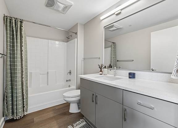 A bathroom with a toilet, sink, and shower.