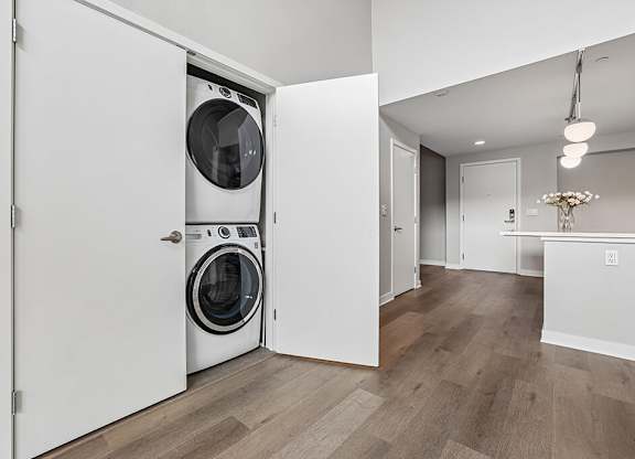A white laundry room with a washer and dryer in a cabinet.