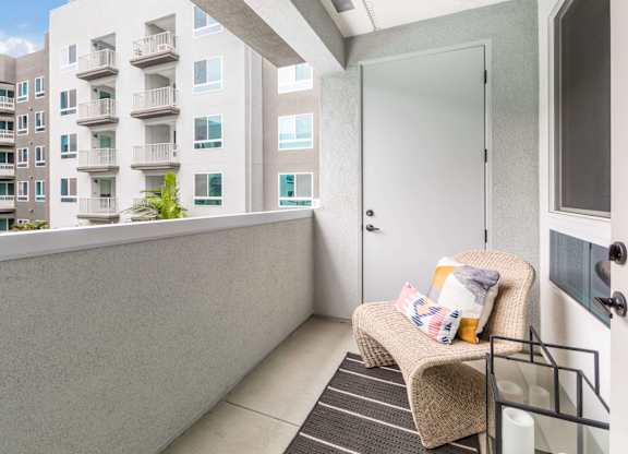 A private balcony with a wicker chair at Avel Apartment Homes in Orange CA