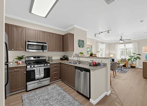 A modern kitchen with brown cabinets and stainless steel appliances.