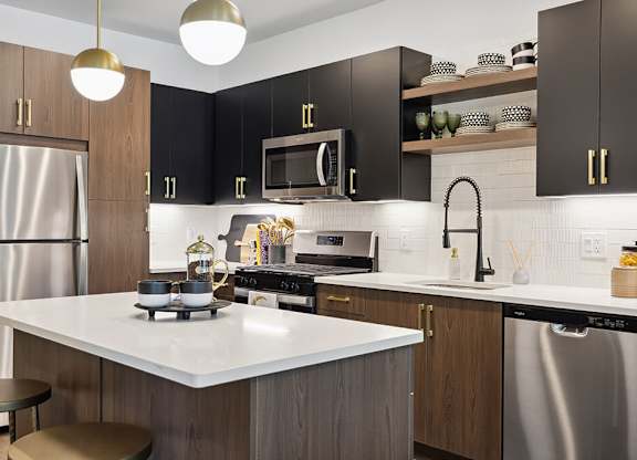 a kitchen with stModel kitchen appliances at Jayden Apartments in Peabody MAainless steel appliances and black cabinets