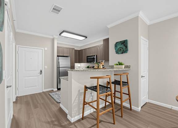 A kitchen with a refrigerator, microwave, and oven.
