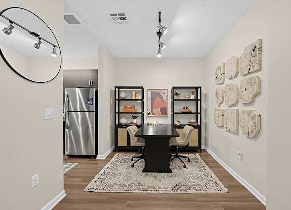 A kitchen with a fridge, a table and a chair.