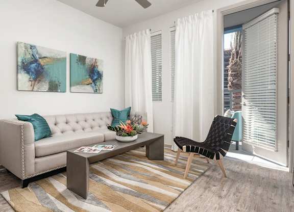 a living room with white walls and a sliding glass door at Norte Town Lake Apartments in Tempe Arizona
